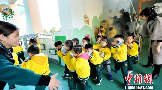 资料图：幼儿园的老师和阿姨引导大班小朋友进行“逃生”应急演练。　卓忠伟 摄